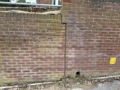 Crack stitching repair to a retaining wall
